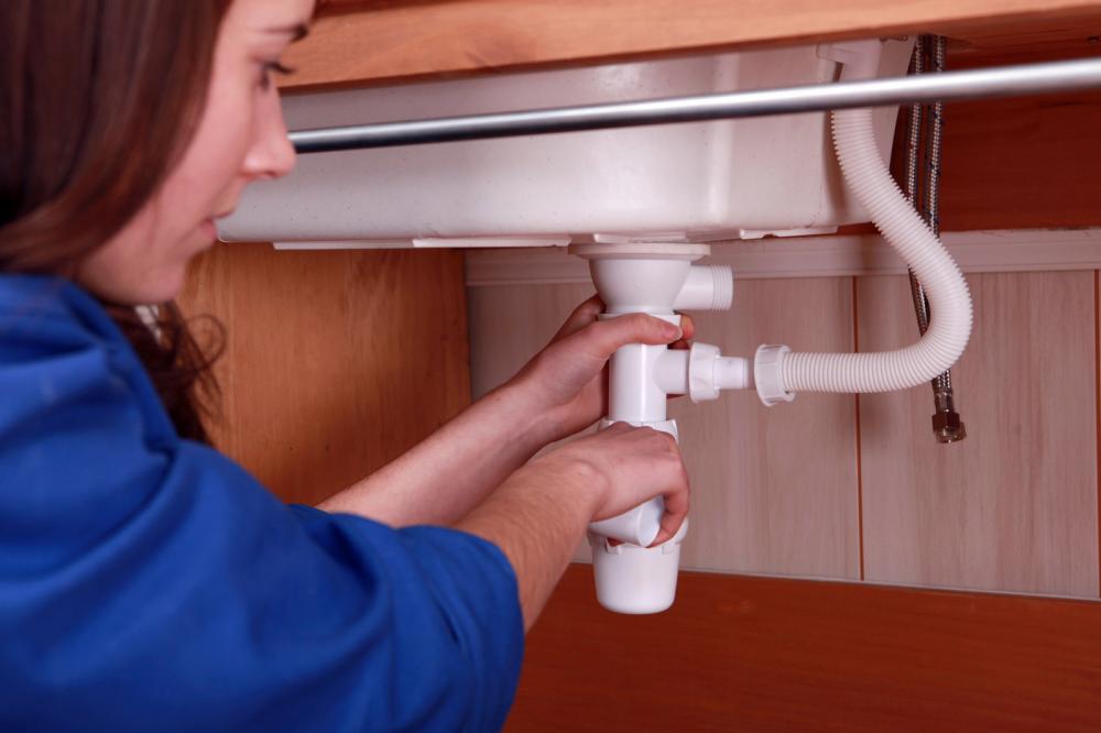 Woman repairing the plumbing on a sink
